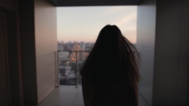Νεαρή γυναίκα ψάχνει στο αστικό τοπίο από ψηλά ουρανοξύστης — Αρχείο Βίντεο
