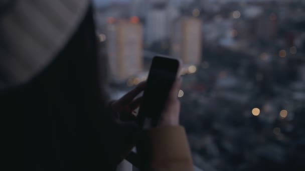 Frau fotografiert Abend Stadtbild von hohen Wolkenkratzer. Nachtbeleuchtung in der Stadt. — Stockvideo