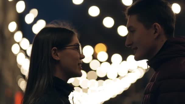Νεαρό ζευγάρι σιλουέτα μέσα σε μια νύχτα street, γιρλάντα φόντο — Αρχείο Βίντεο