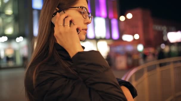 Γυναίκα μιλώντας από έξυπνο τηλέφωνο στην πόλη το βράδυ — Αρχείο Βίντεο