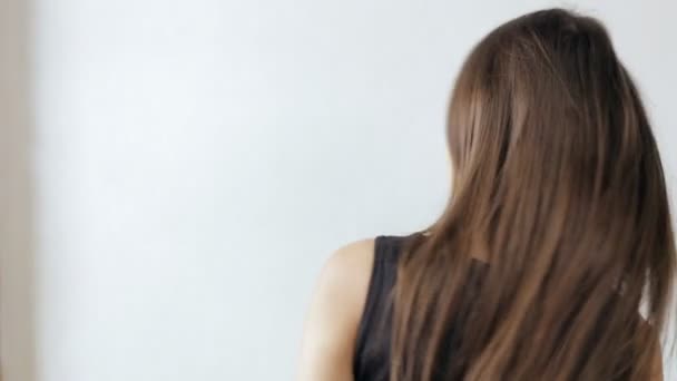 Mujer atractiva lanzando pelo sobre fondo blanco, cámara lenta — Vídeos de Stock