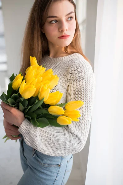 Portrait of beautiful woman holding yellow tulips — Stock Photo, Image