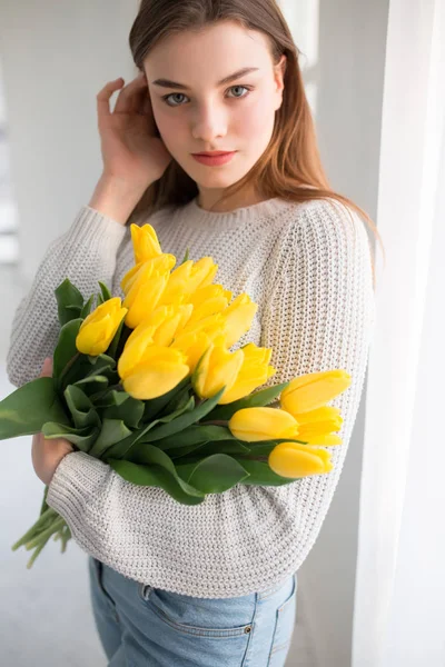 Portrait of beautiful woman holding yellow tulips — Stock Photo, Image