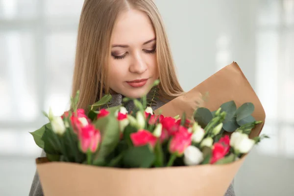 Vrouw kijken naar witte en roze rozen boeket in studio — Stockfoto