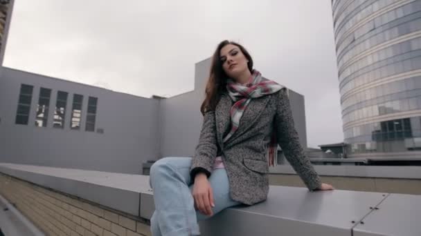 젊은 여자에 앉아 지붕 고 도시 풍경 — 비디오