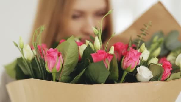 女人嗅玫瑰花束在工作室 — 图库视频影像