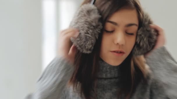 Девочка-подросток наслаждается музыкой в пушистых наушниках — стоковое видео