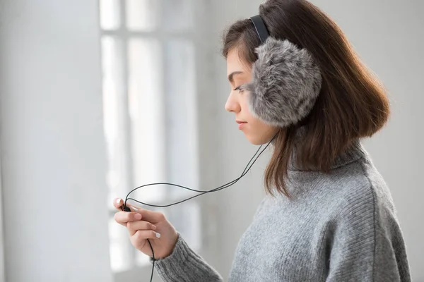 Chica adolescente en audífonos esponjosos escuchar música — Foto de Stock