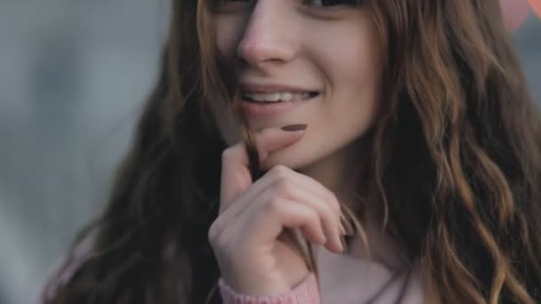 Nahaufnahme Porträt - hübsche Frau spielt in urbaner Szene mit Haaren — Stockvideo