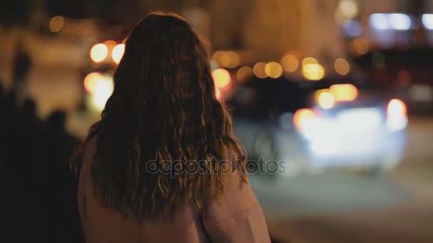 Жіночий силует на фоні нічного дорожнього руху - вид ззаду — стокове відео