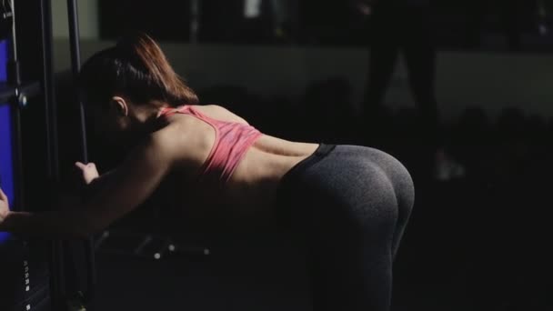 Αθλητισμός γυναίκα στο γυμναστήριο κάνει άσκηση σε μια συσκευή κατάρτισης — Αρχείο Βίντεο