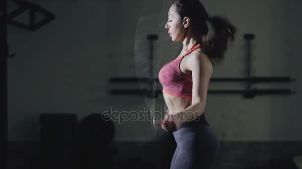 Жінка робить вправи стрибати мотузку в тренажерному залі — стокове відео