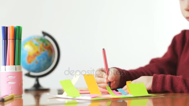 Menino desenha um marcadores em papel colorido, fundo branco . — Vídeo de Stock