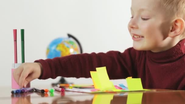 Niño dibuja marcadores en papel de color, fondo blanco . — Vídeos de Stock