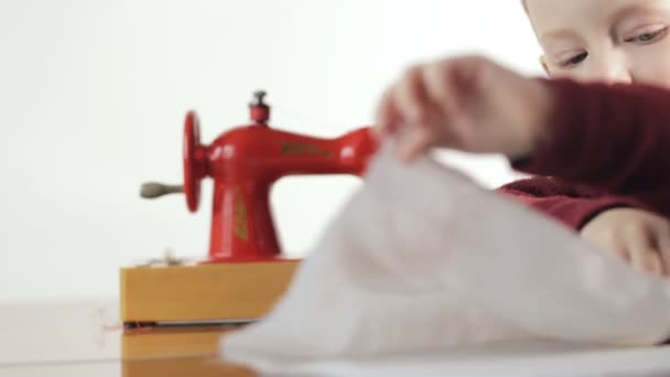 Liten pojke sy tyget på symaskinen - vit bakgrund — Stockvideo