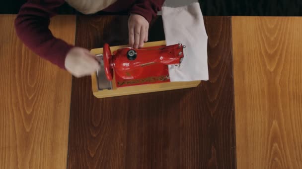 Niño pequeño coser la tela en la máquina de coser - vista superior — Vídeos de Stock