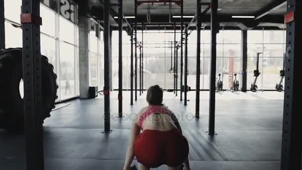 Frau im Fitnessstudio geht mit Hantel — Stockvideo