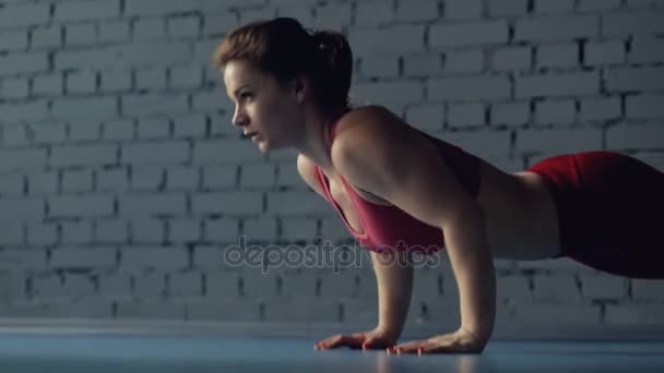 Sportovní žena push up v tělocvičně