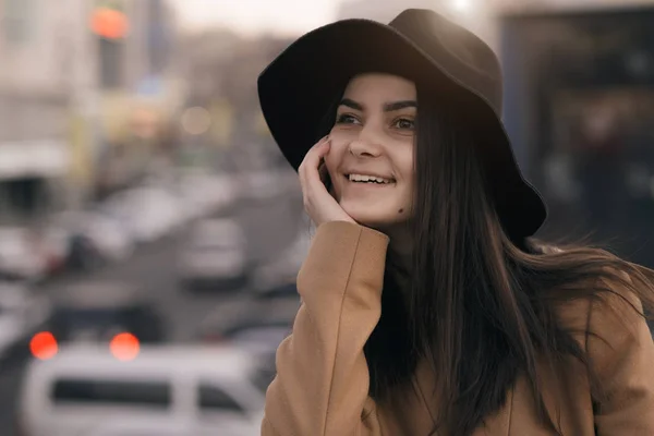 Funky nő kalapban, mosolyogva, és a szórakozás, városi háttér — Stock Fotó