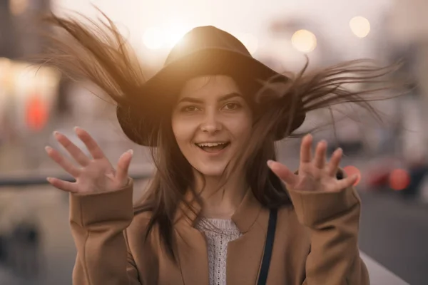 ผู้หญิงขี้ขลาดในหมวกยิ้มและมีความสุขภูมิหลังเมือง — ภาพถ่ายสต็อก