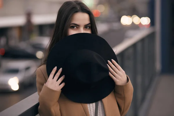 Mujer divertida escondida detrás de un sombrero en la ciudad —  Fotos de Stock