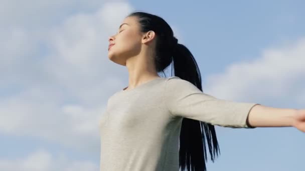 Mujer relajándose en una libertad, fondo azul del cielo — Vídeo de stock