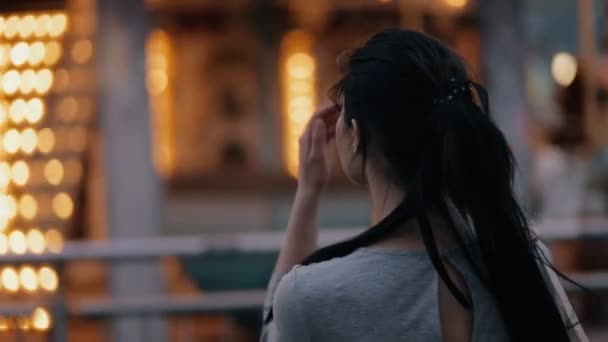 Hübsche Frau sucht Karussell in einer Nachtstraße — Stockvideo