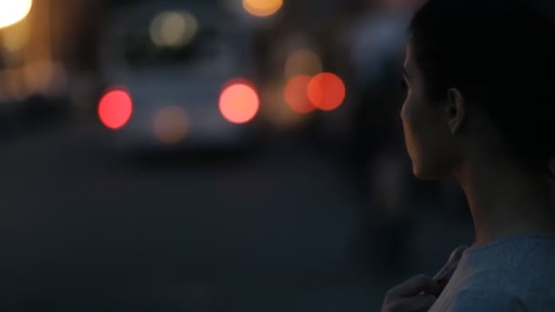 Femme élégante marchant dans une ville nocturne - vue arrière — Video