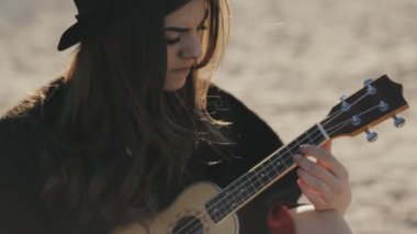 Ukulele plajda oynarken mutlu genç kadın