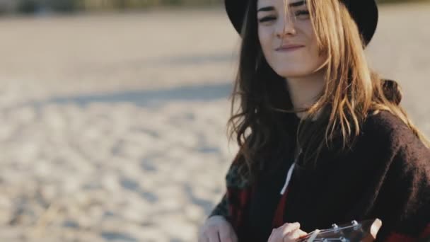 Glad ung kvinna som spelar på ukulele på stranden — Stockvideo