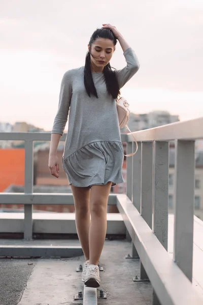 Tyylikäs nainen kävelee katolla iso rakennus — kuvapankkivalokuva