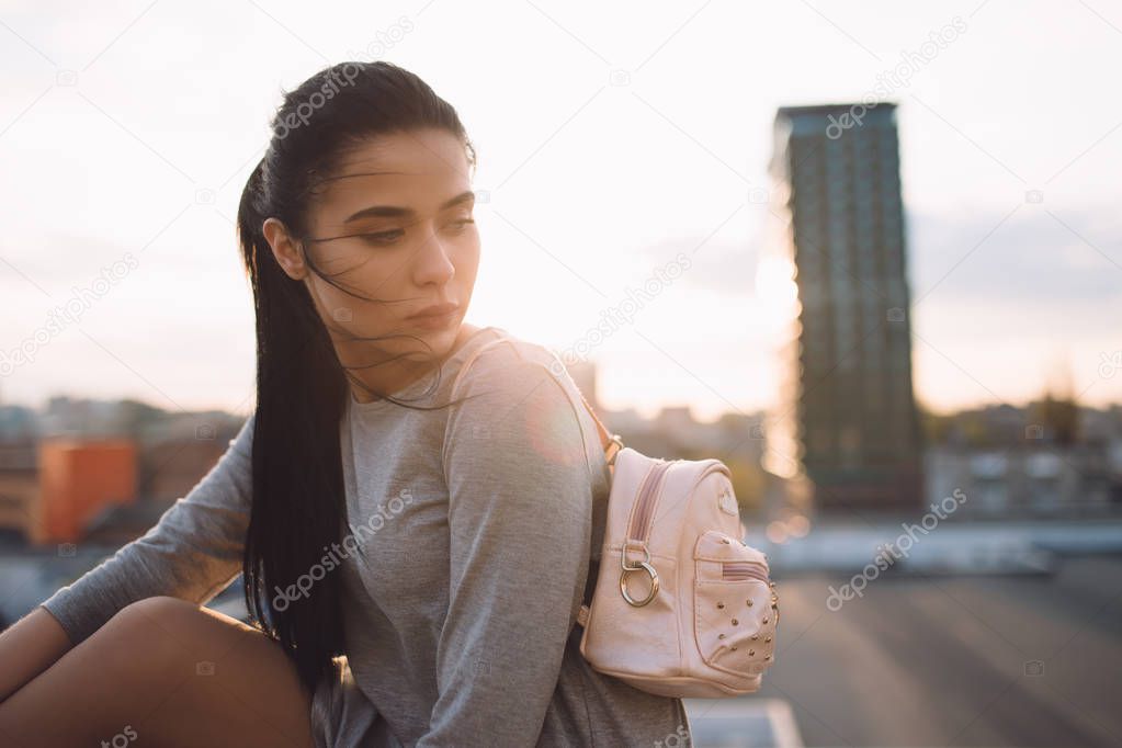 Stylish woman sitting on roof and relaxing