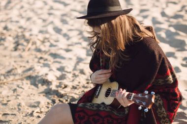 Ukulele plajda oynarken mutlu genç kadın