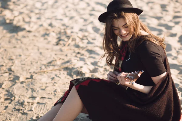 Jovem feliz jogando no ukulele na praia — Fotografia de Stock