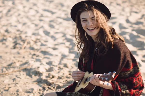 Jovem feliz jogando no ukulele na praia — Fotografia de Stock