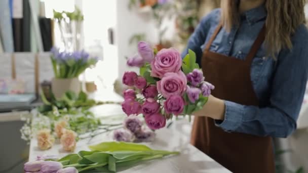 Цветочница делает букет из красивых цветов — стоковое видео