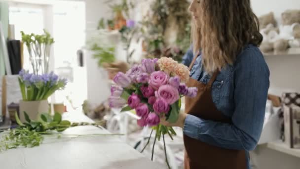 Γυναίκα ανθοκόμος κάνει μια ανθοδέσμη των όμορφων λουλουδιών — Αρχείο Βίντεο