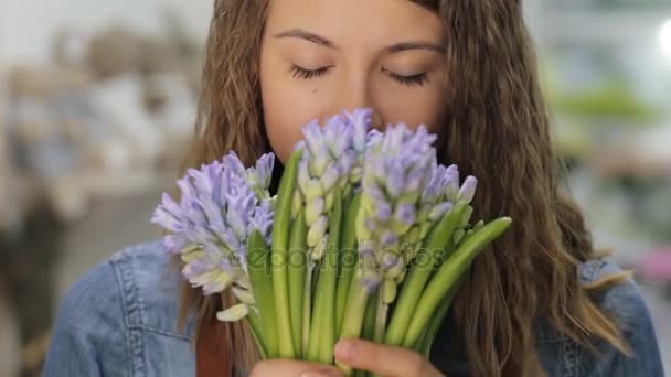 Mujer florista olfatear un buen aroma de flores — Vídeos de Stock