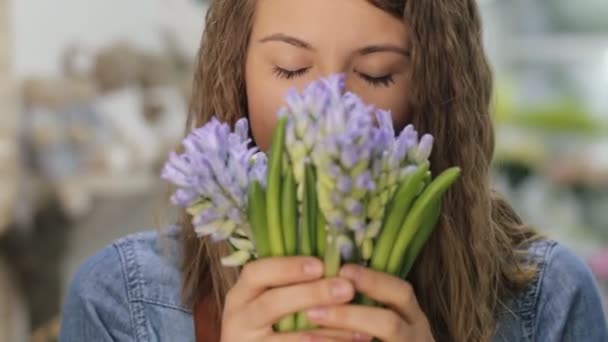 Женщина флорист нюхает хороший аромат цветов — стоковое видео
