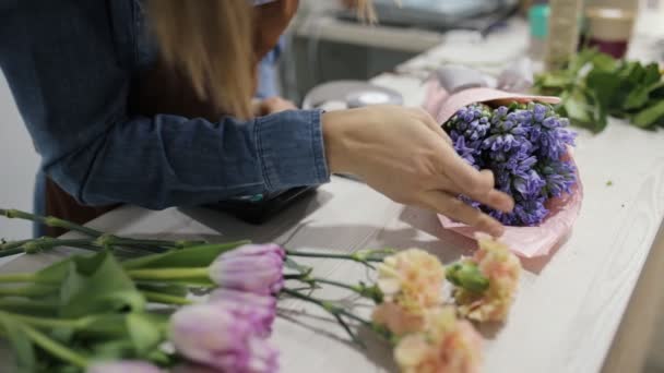 Ανθοπωλείο γυναίκα τον υπολογισμό τιμής του μπουκέτο με λουλούδια — Αρχείο Βίντεο