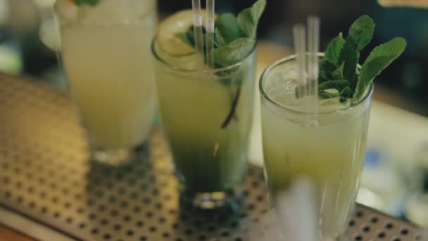 酒保把 kivi 放在莫吉托鸡尾酒和花玻璃 — 图库视频影像