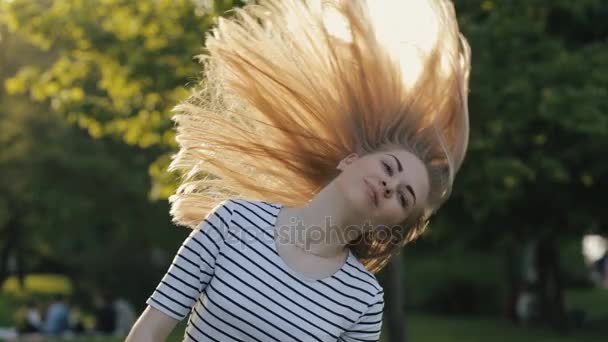 Adolescente menina jogando cabelo em um parque — Vídeo de Stock