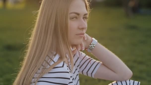 Adolescente assise sur l'herbe et souriant à la caméra — Video