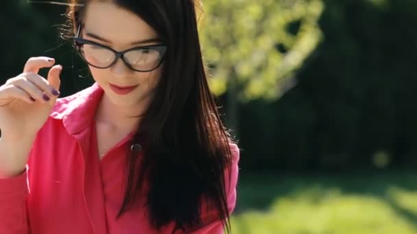 Sexy jolie femme portant des lunettes de soleil dans un parc 