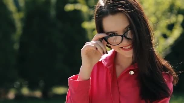 Sexy jolie femme portant des lunettes de soleil dans un parc 