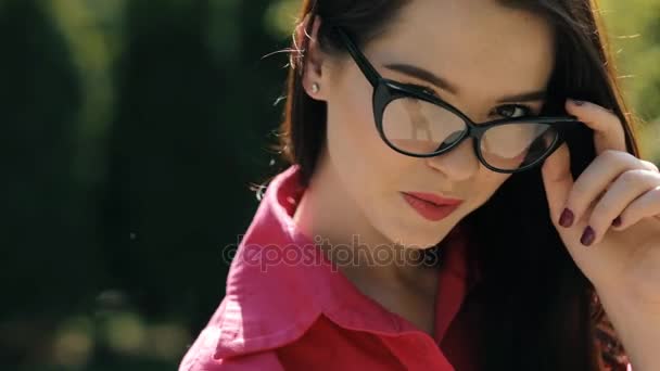 Σέξι όμορφη γυναίκα που φοράει γυαλιά ηλίου σε ένα πάρκο — Αρχείο Βίντεο