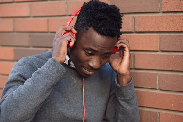 Hombre afroamericano escucha música en la ciudad — Foto de Stock