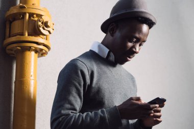 Afrika kökenli Amerikalı adam sıhhi tesisat yanında istimal hareket eden telefon