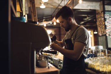 Genç erkek barista kahve makinesi de içki hazırlama