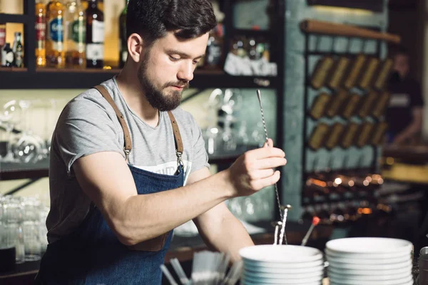 Ung manlig bartender förbereder en alkohol cocktail — Stockfoto